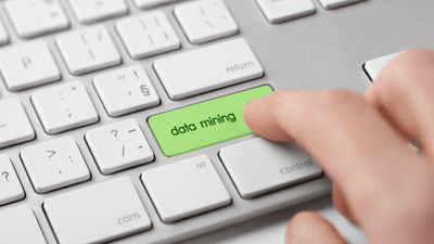 A person pressing the 'data mining' key